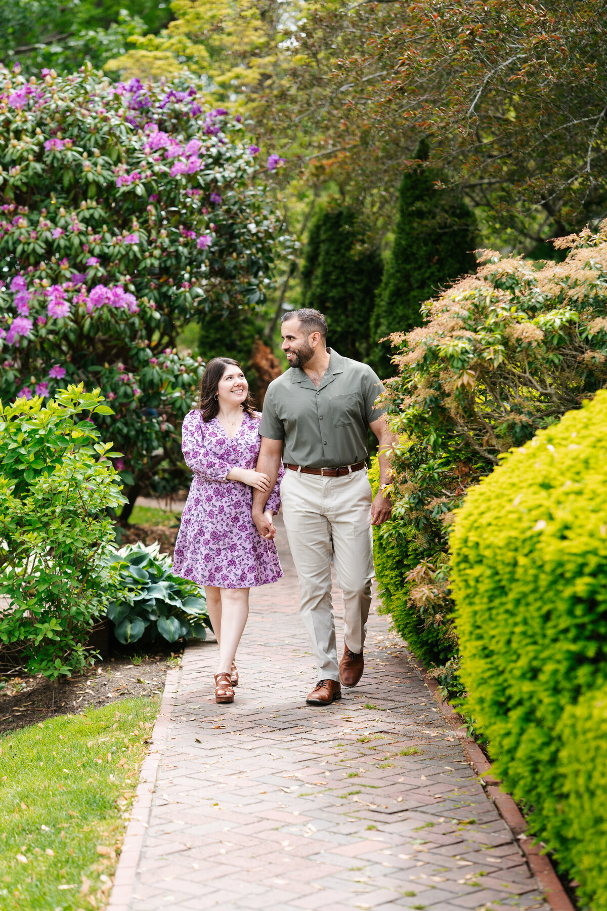 Couple walking through the rose garden at Lynch Park during their Beverly engagement session with Danielle Littles Photography