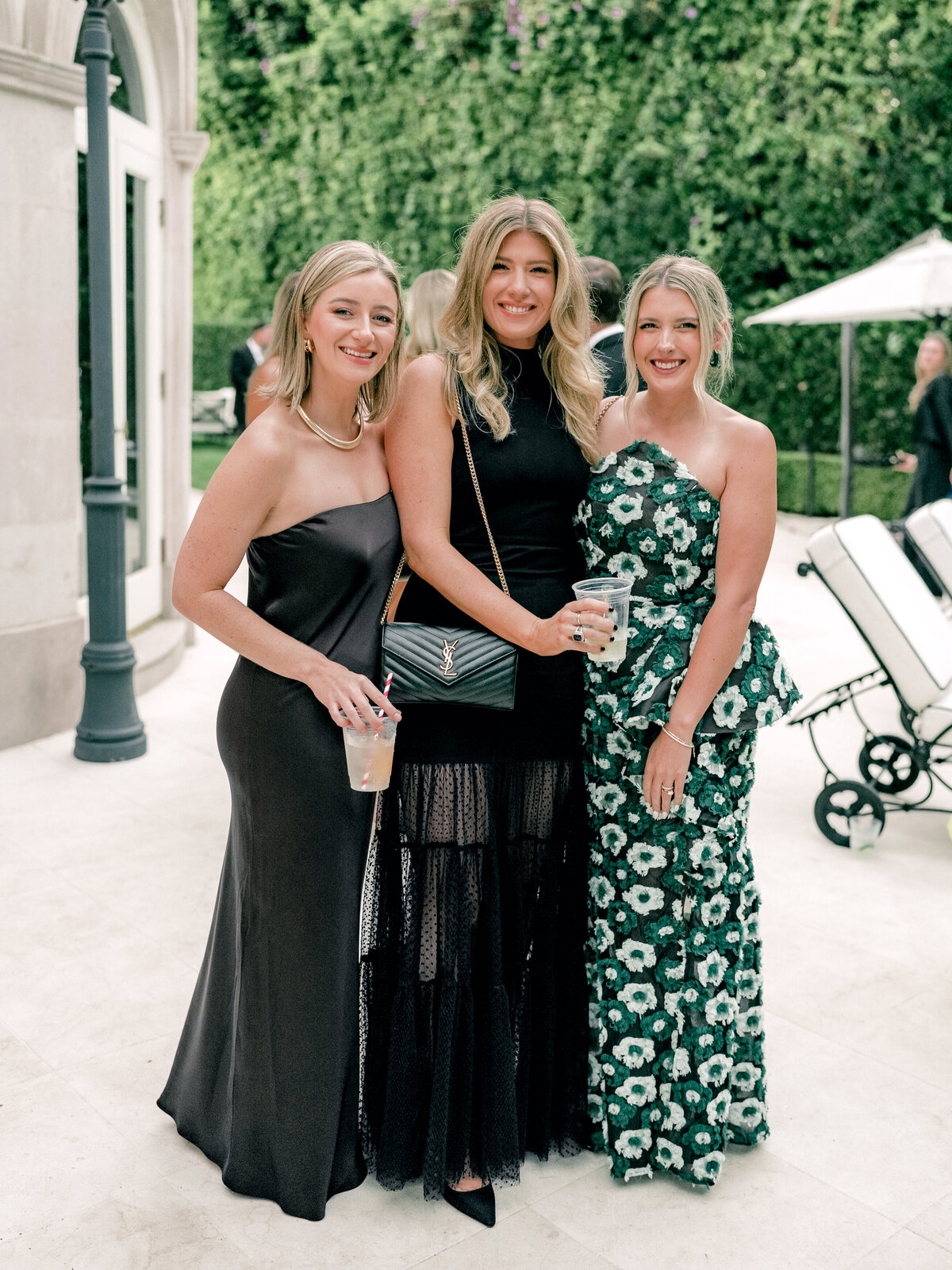 Group photo of three wedding guests in fashion forward dresses