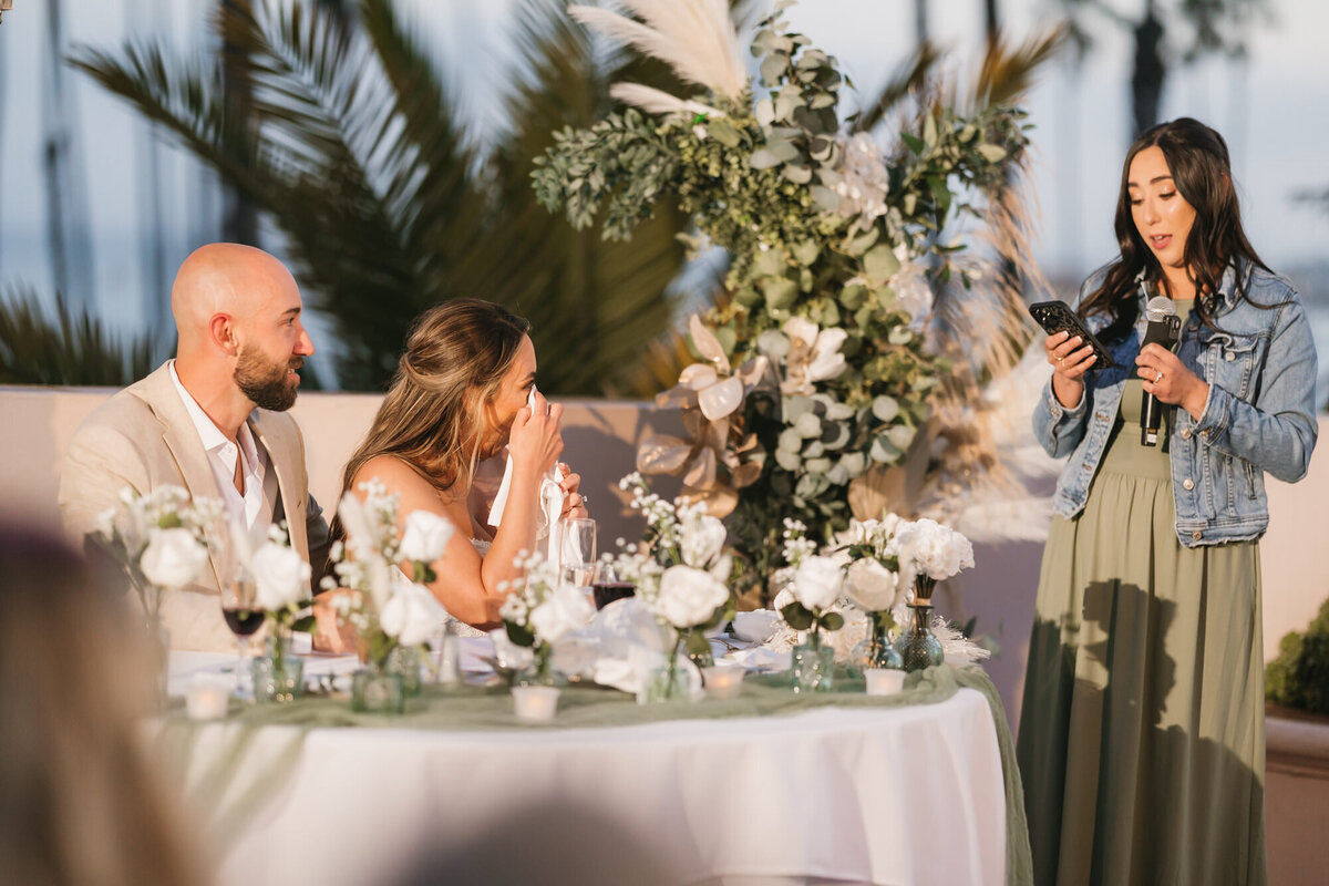 Bride wiping tear during maid of honor speech at Hilton Beachfront Resort Santa Barbara