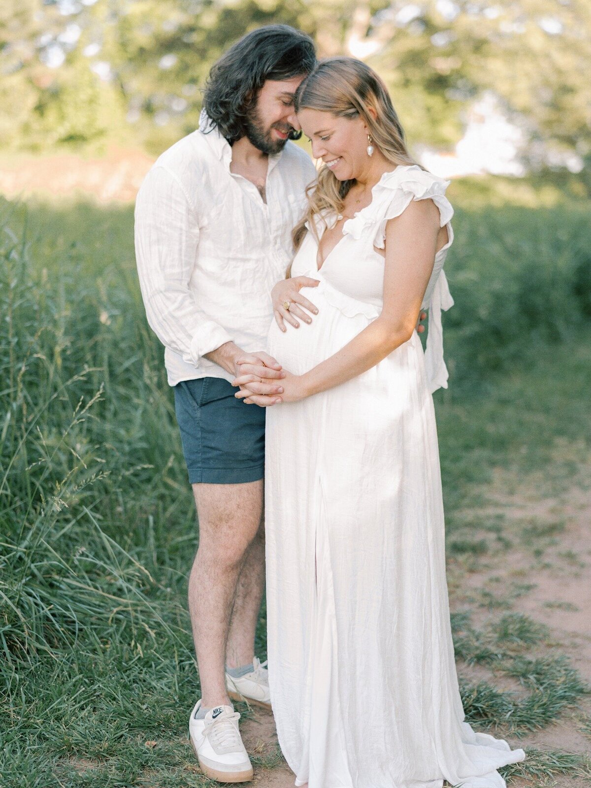expecting-couple-holding-hands-in-meadow