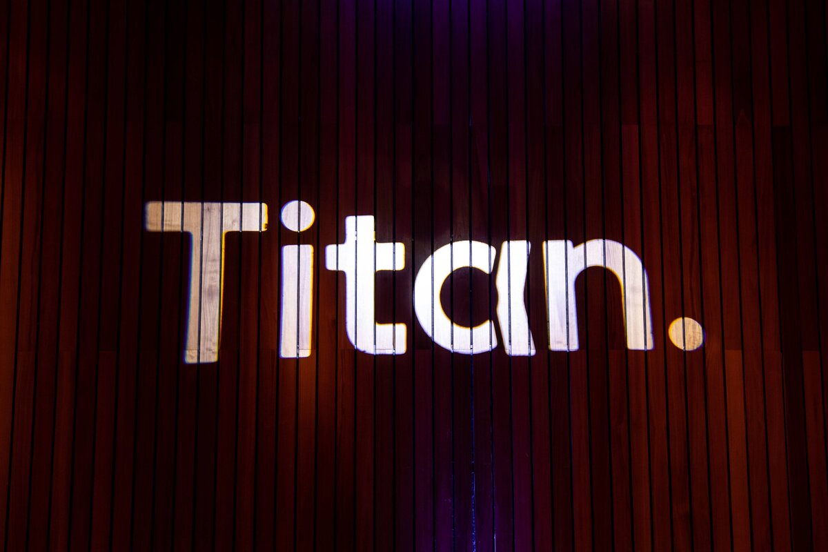 Titan logo illuminated on a wooden wall.
