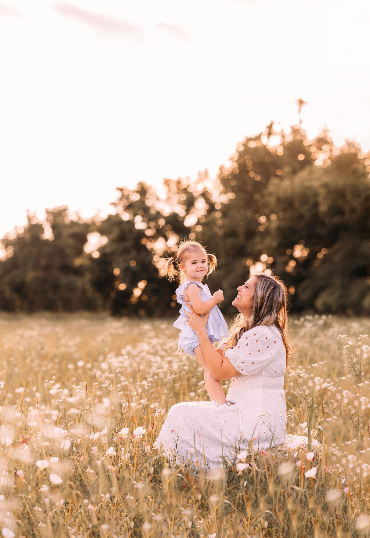 mother holds daughter in wildflower field in oklahoma city