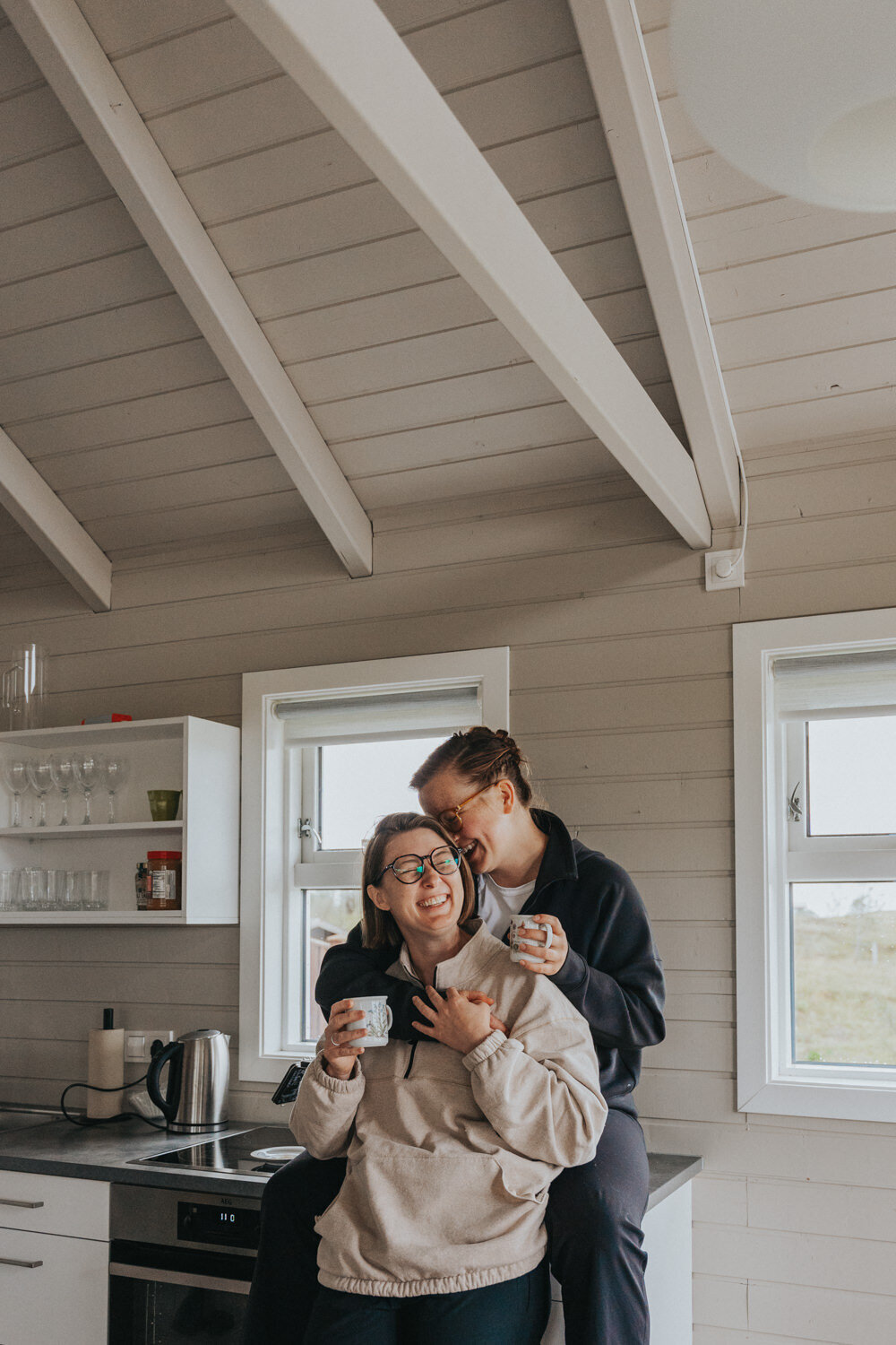 Two women embrace inside their cozy Iceland cottage 