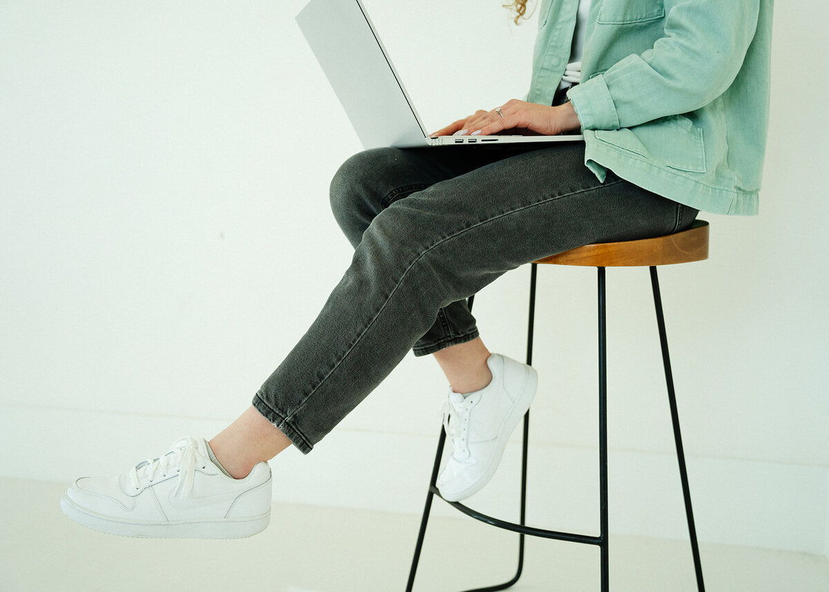 Close up shot of Haylee Harris designing a custom website on her laptop.