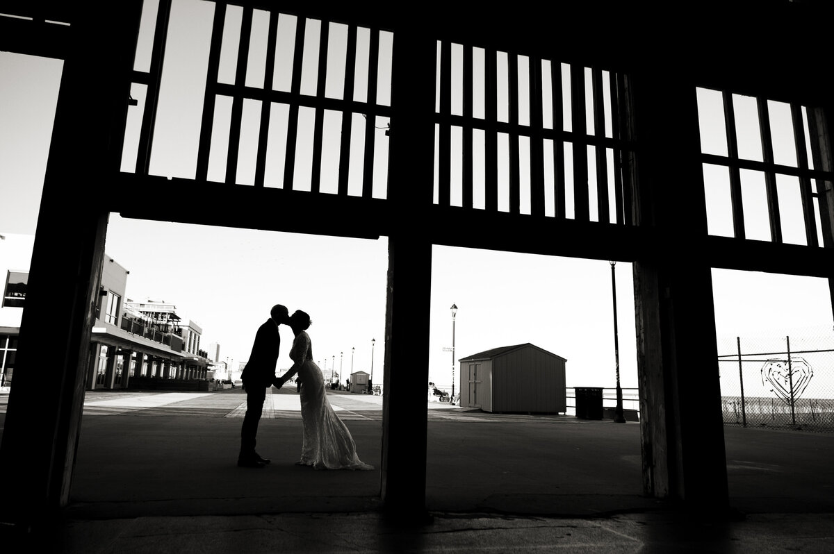A newlywed couple leaning into each other and kissing 