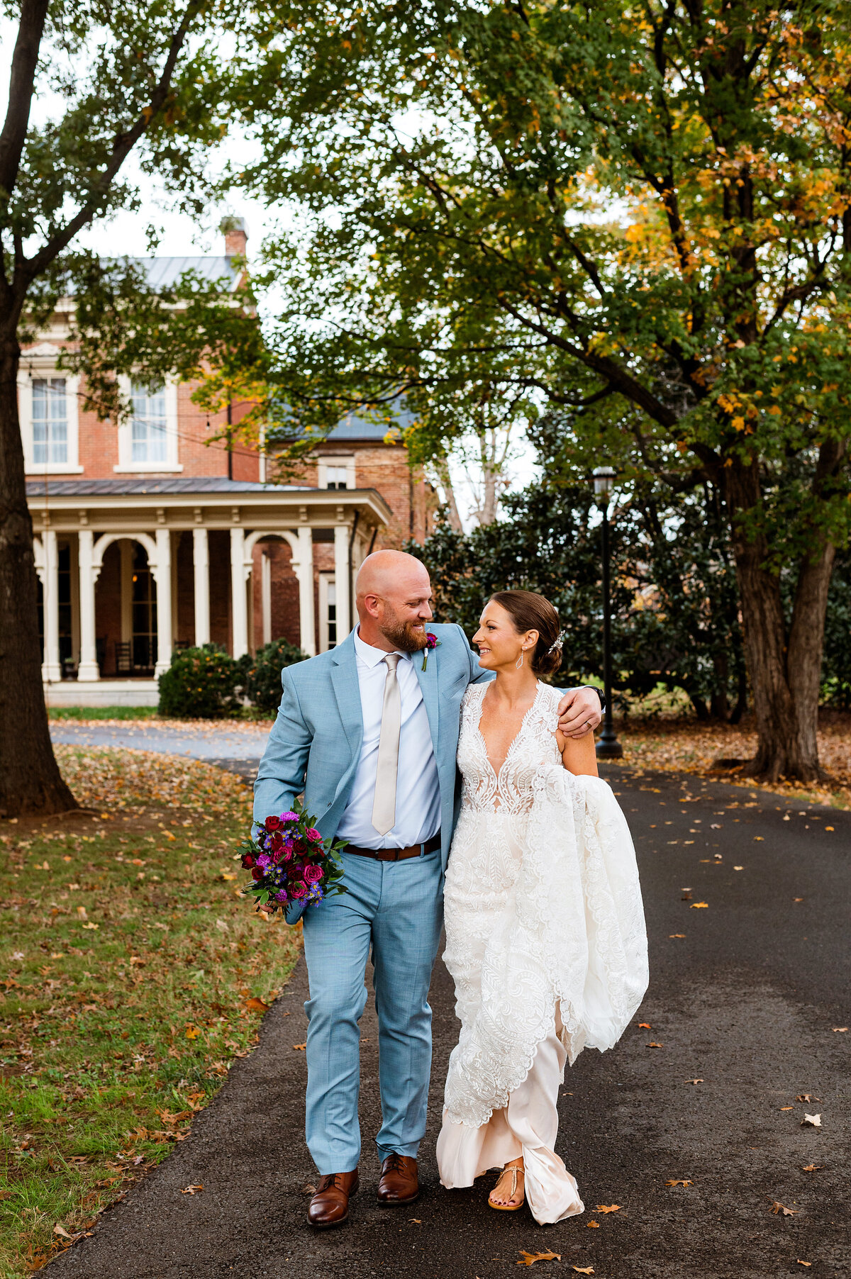 Newlyweds walking outside of Oaklands Mansion snuggled together