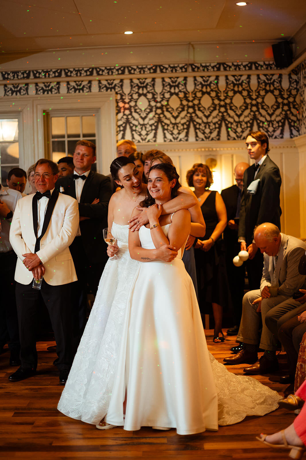 Two brides hugging on the dance floor
