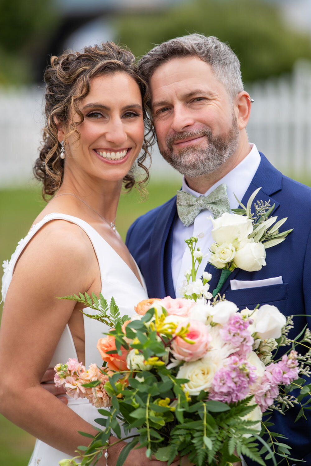 Smiling couple holding a pastel bouquet outdoors