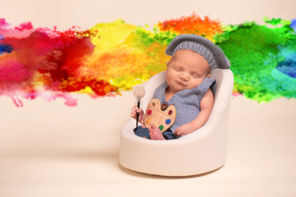 Newborn painter themed in a vibrant rainbow-themed setup, captured in Overland Park, Kansas. Perfect for families looking for colorful and meaningful newborn photography themes in the Kansas City metro area.