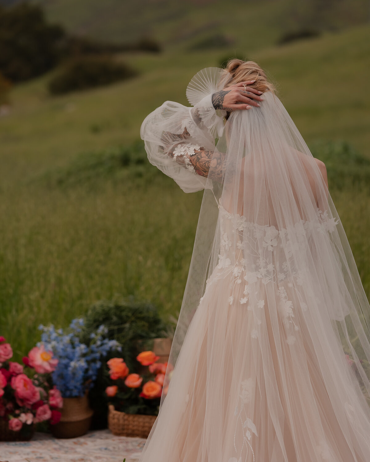 Elopement weddings photos bride veil photo with flowers in back ground and green field in San Luis Obispo at Higuera Ranch