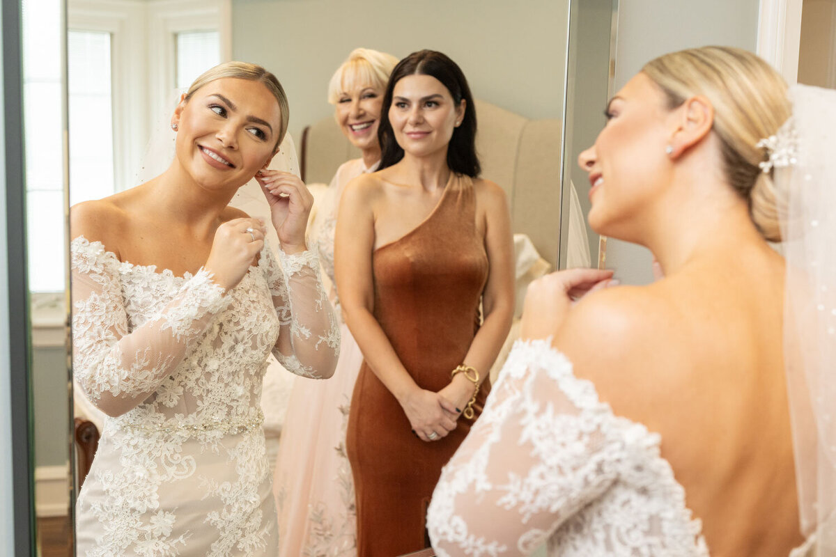 A group of women are standing in front of a mirror