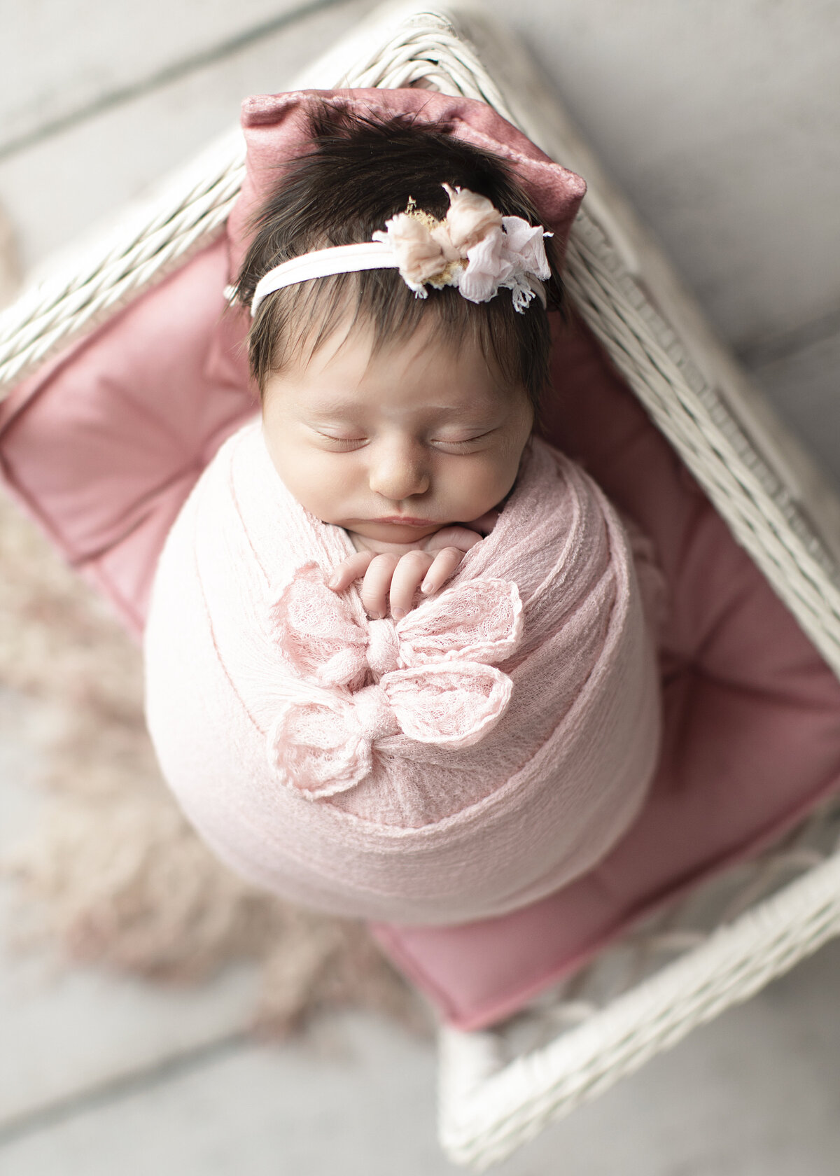 Baby girl wrapped in pink sleeps for newborn pictures