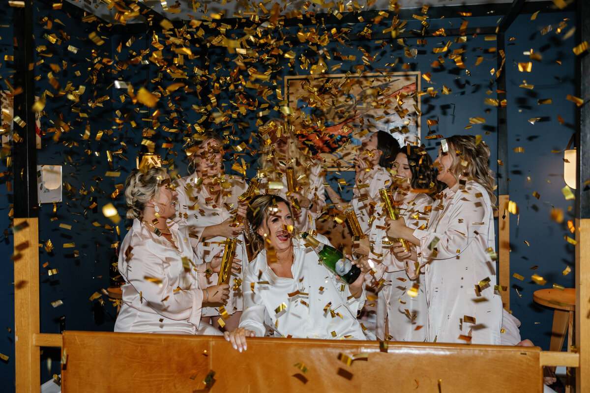 Bride popping confetti during getting ready portraits before a wedding in Baltimore, MD