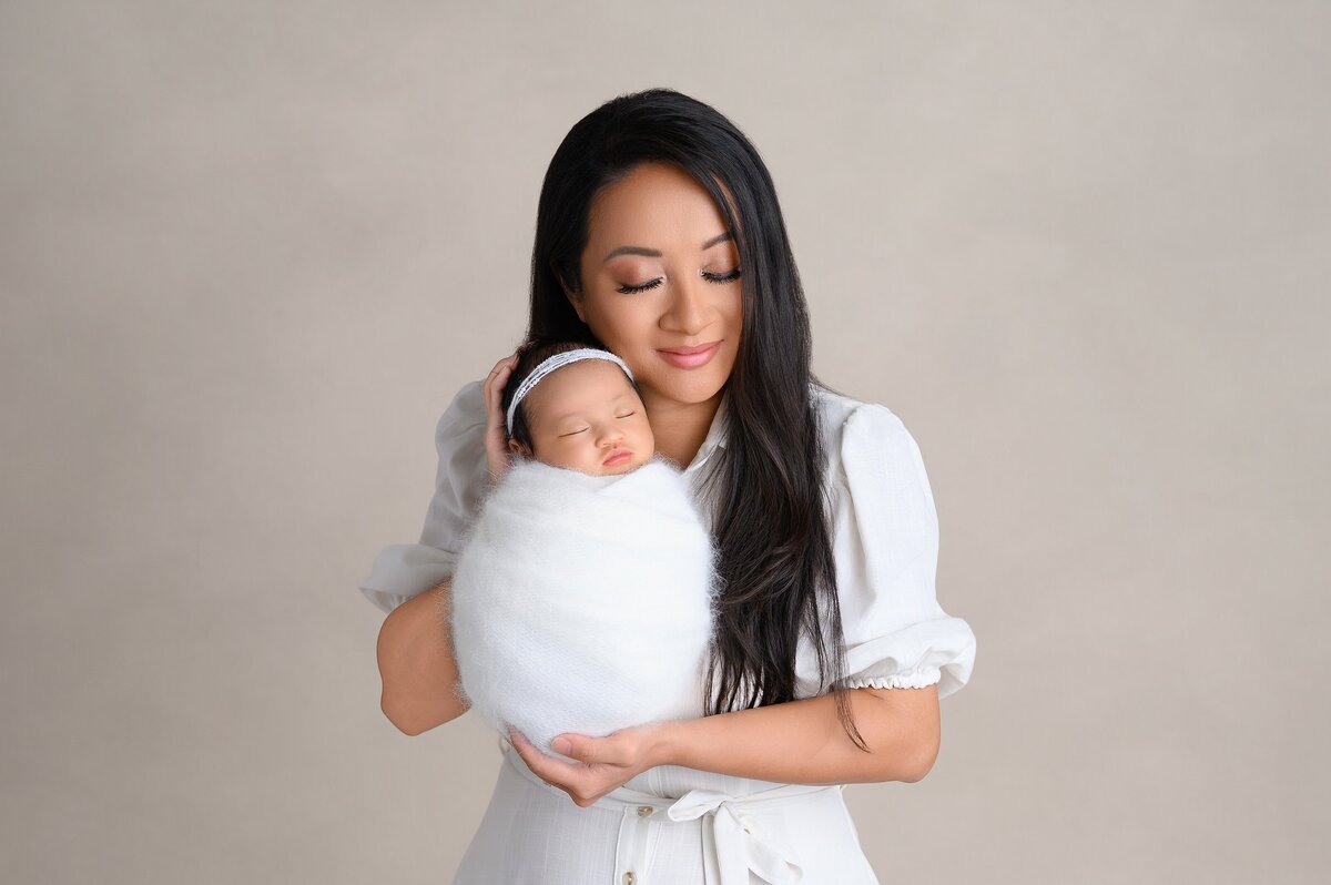 Newborn and mommy pose in newborn photography studio located in South Florida.
