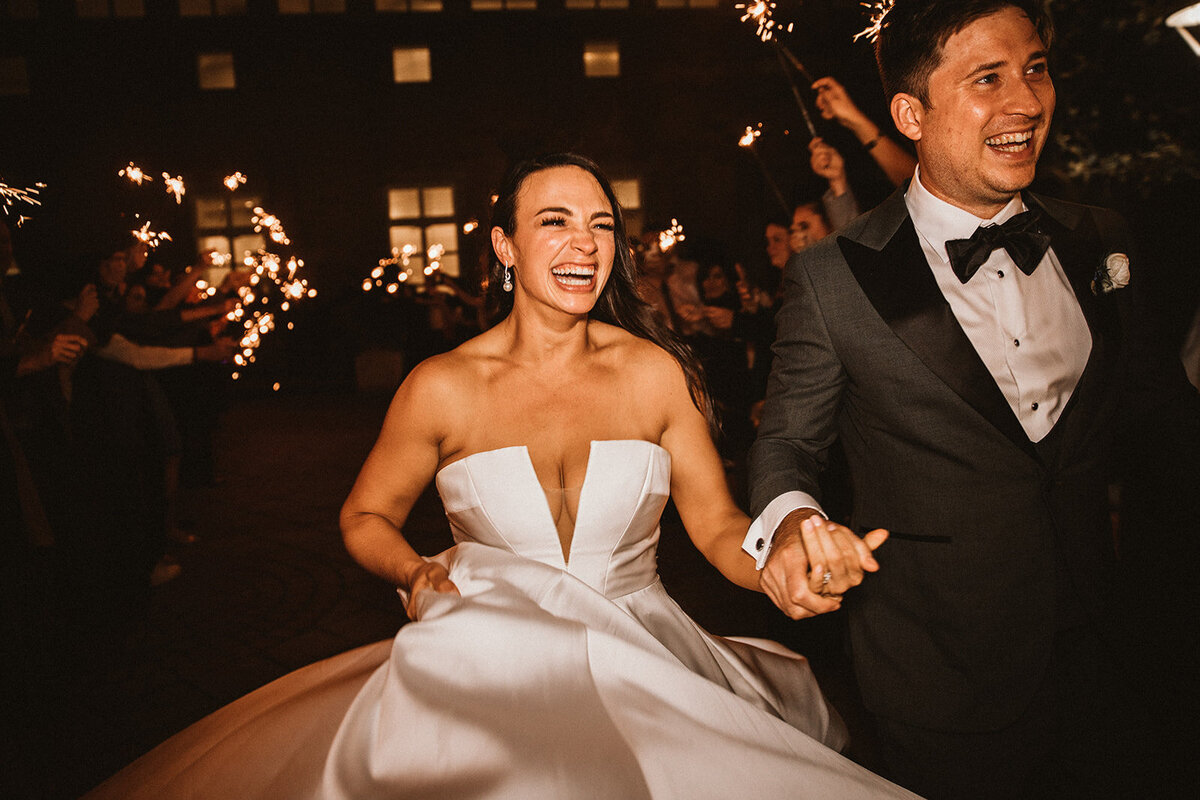 bride and room laugh during sparkler exit