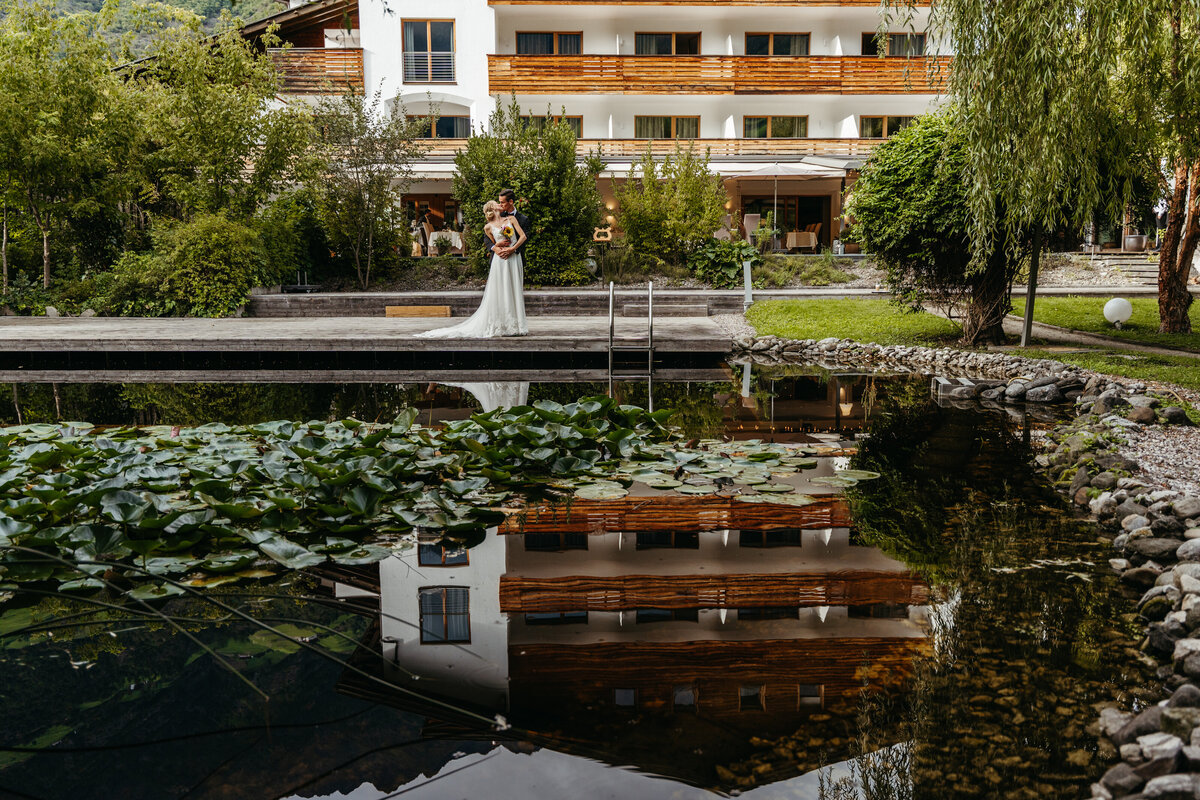 Wedding ceremony setup reflected in natural pond