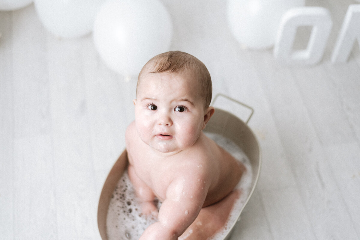 baby boy in a bath tub at cake smash photoshoot in billingshurst