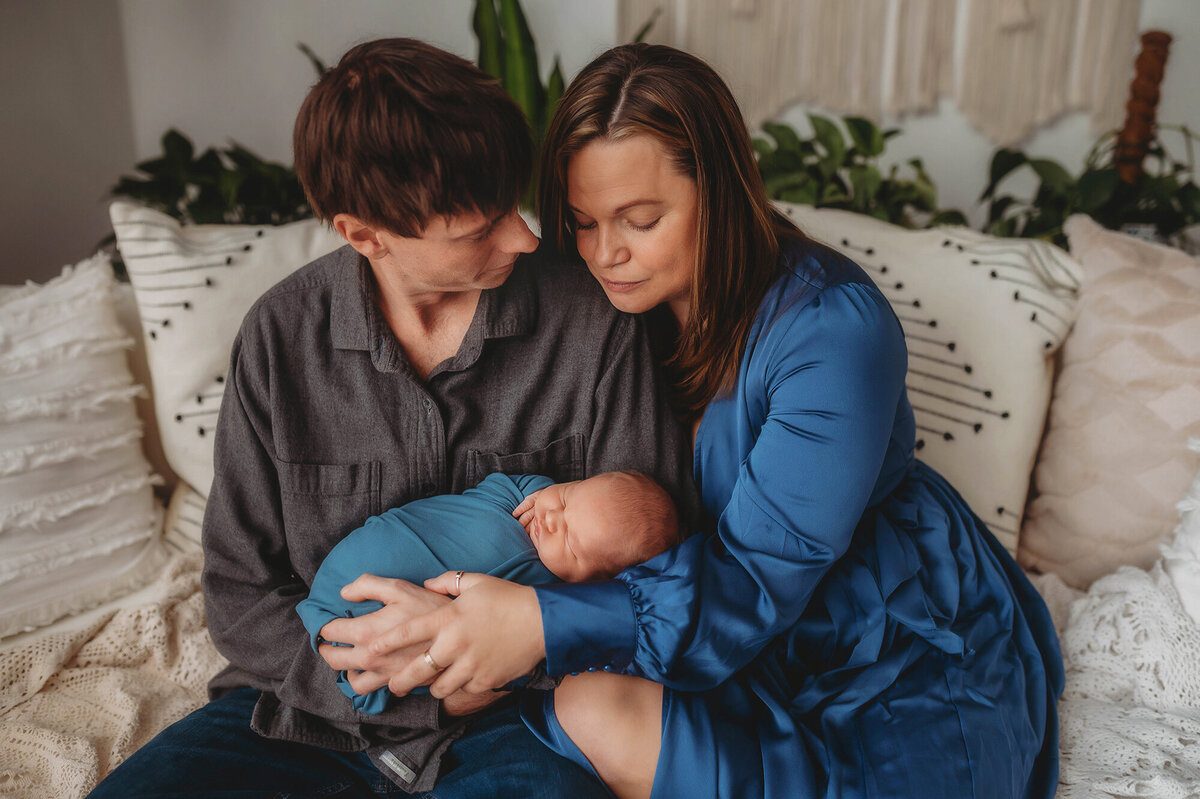 Parents embrace their baby during Newborn Photos in Charleston.