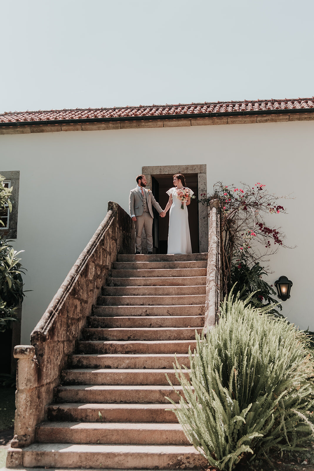Bride & Groom walking hand in hand down the steps of Casa Grande de Fontao at their wedding in Portugal