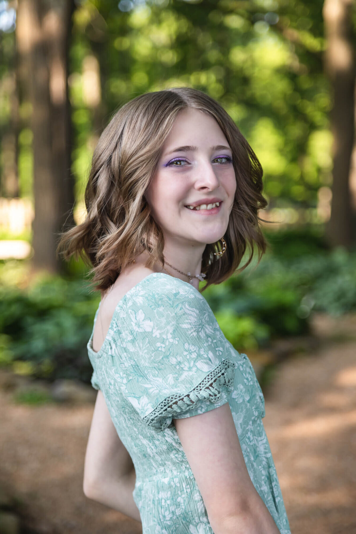Portrait of a smiling teen girl with a short blonde bob, and striking green eyes. Captured by Springfield, MO teen photographer Dynae Levingston.