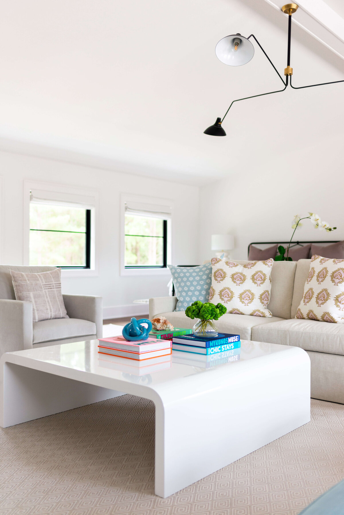 oyster creek studios building belt new build gray armchair and ivery couch with patterned pillows and white modern coffee table in living room