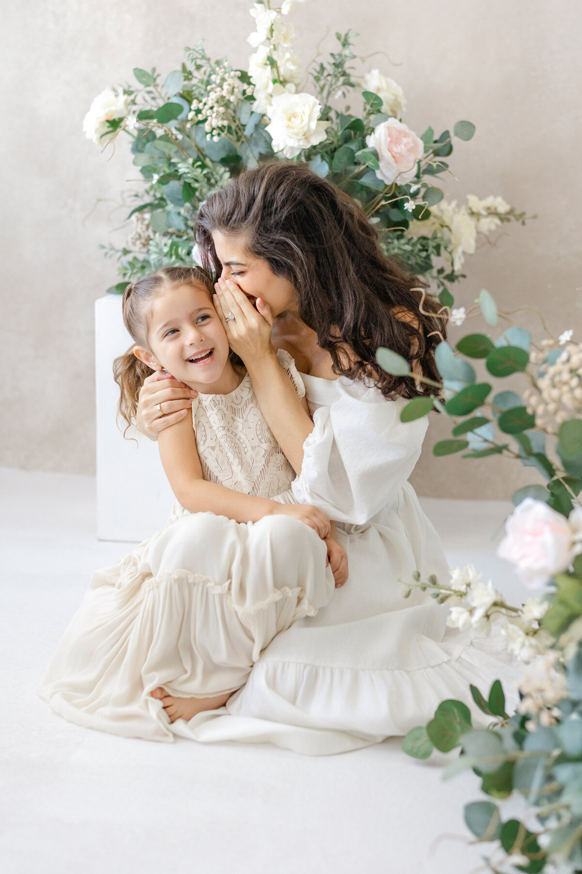 Joyful Tampa motherhood portrait of mom and daughter laughing together in soft natural light studio