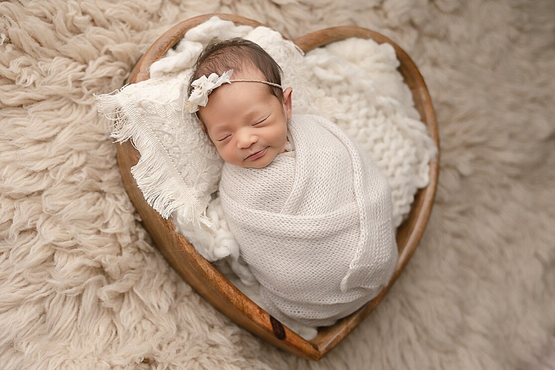 baby girl in heart bowl for newborn pictures in portland area studio