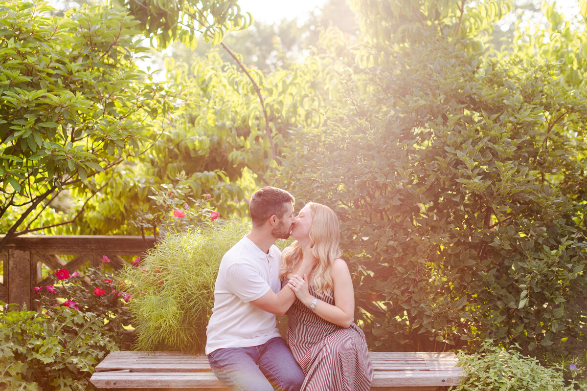 couple-kissing-on-bench-in-Untermyer-Gardens