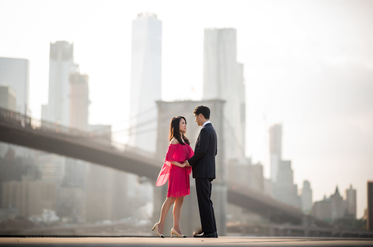 A couple holding hands with a city skyline behind them.