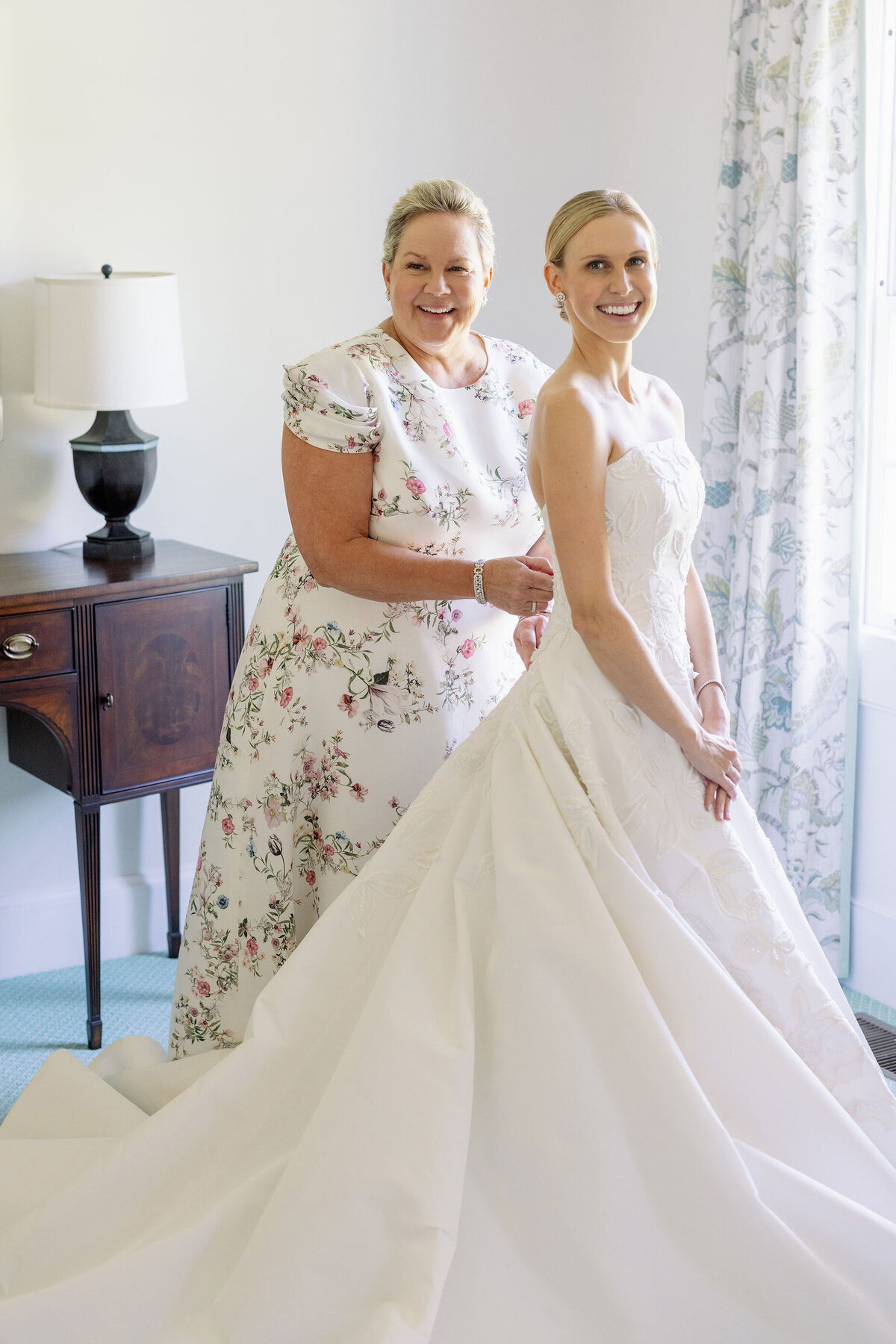 A photo of the mother of the bride helping the bride get ready for the wedding. 