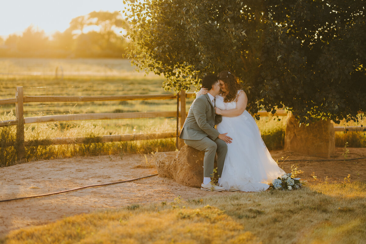 Couple seated by the fence at sunset
