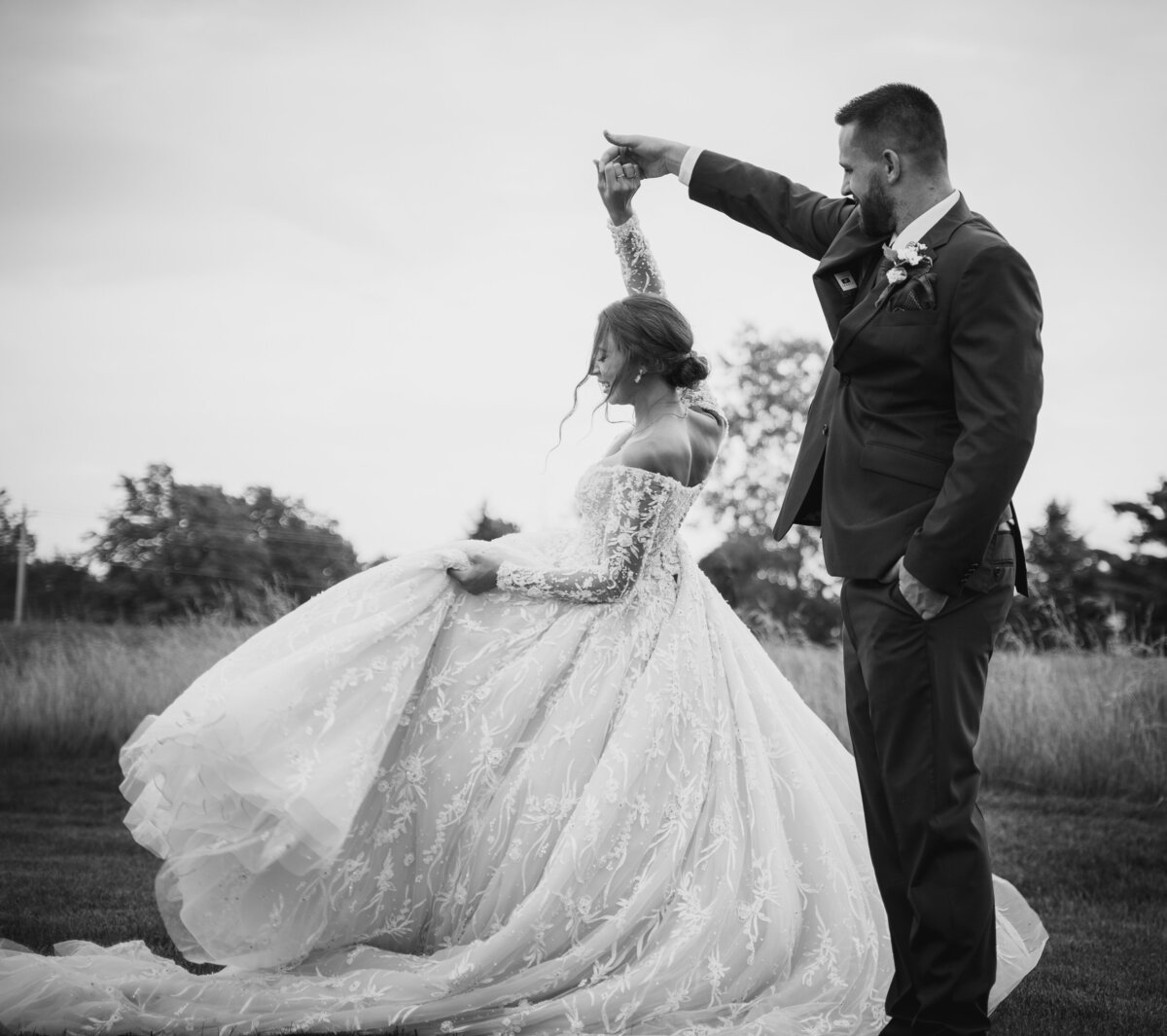 The groom, Ryan Bee, twirls his bride, Mahalie in her magnificent lace ballgown at their wedding at The Old Blue Rooster Event Center LLC in Lithopolis, Ohio.