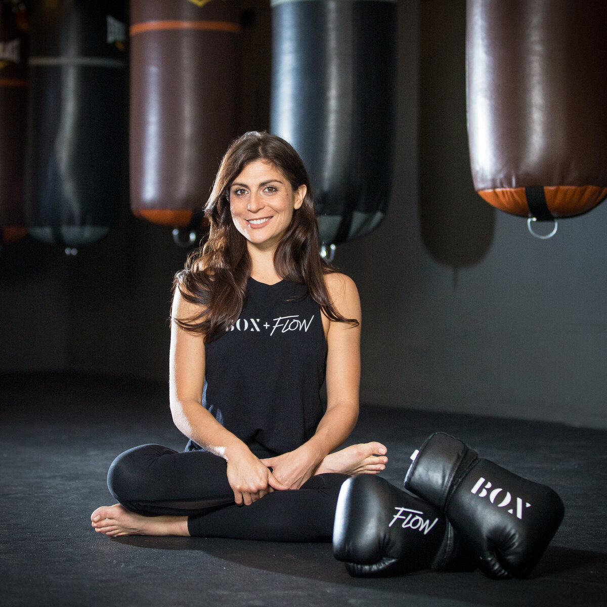 woman sitting next to boxing gloves