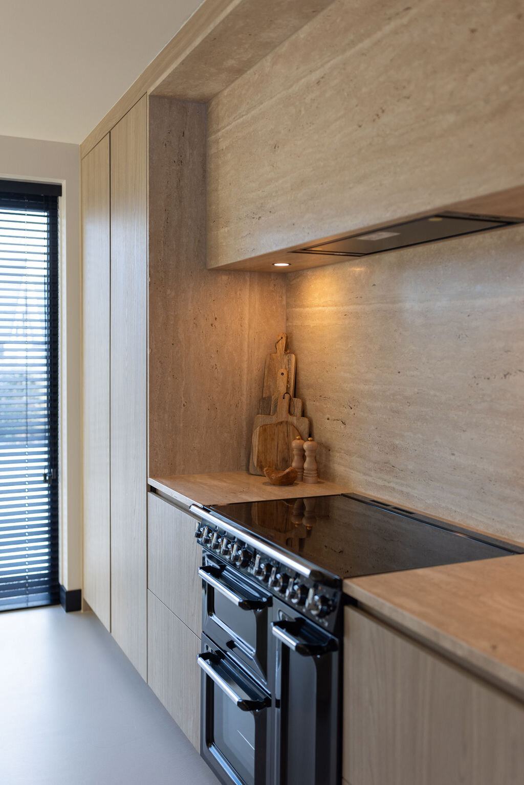 Keuken met een Travertin aanrechtblad en moderne accenten voor een industriële uitstraling.