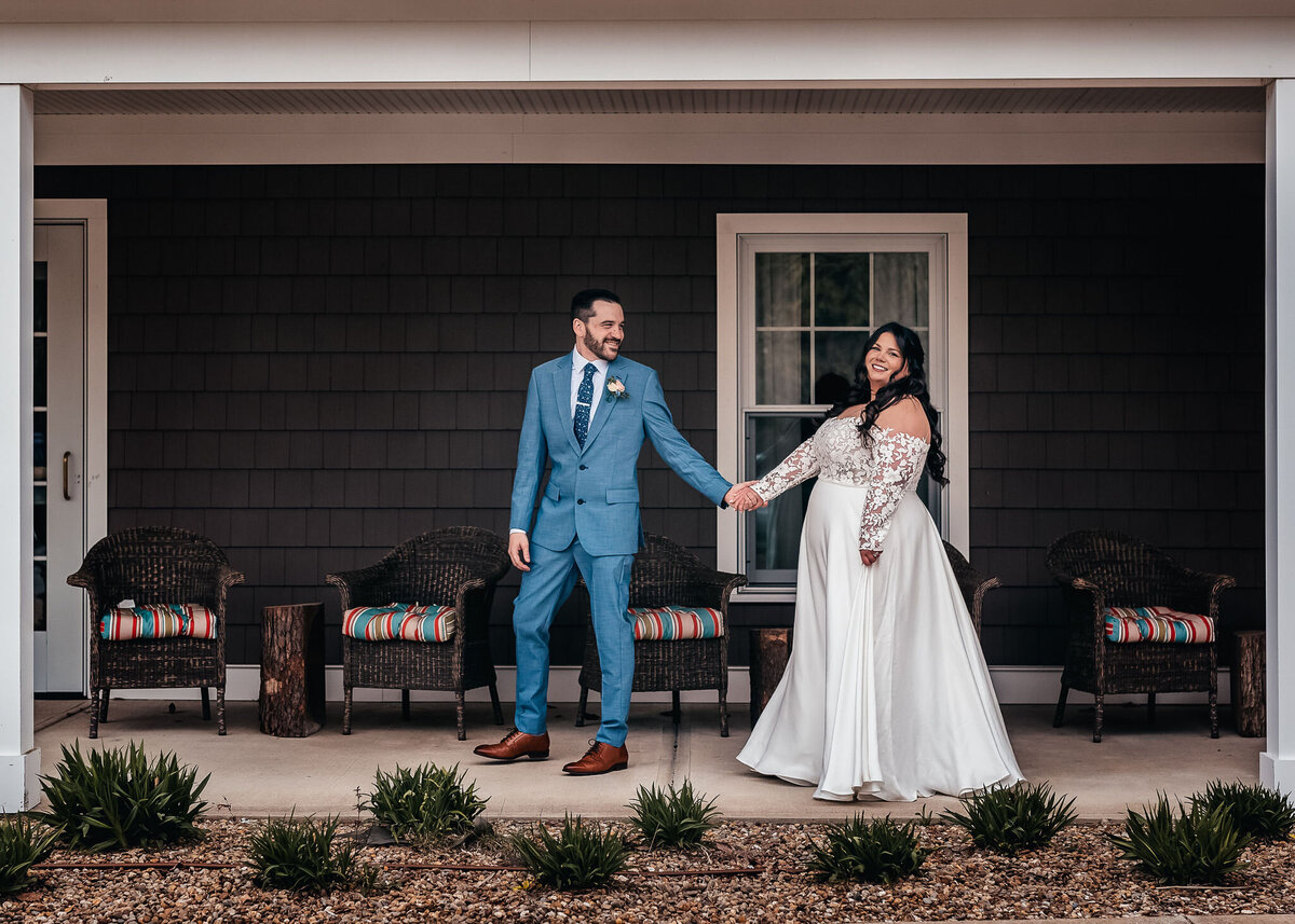 Bride and groom walking along porch at Bedford Village Inn wedding by Lisa Smith Smith Photography