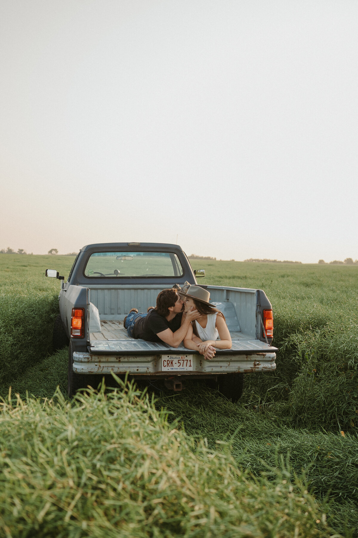 Photograph of couple kissing in the back of their pick up truck in Edmonton