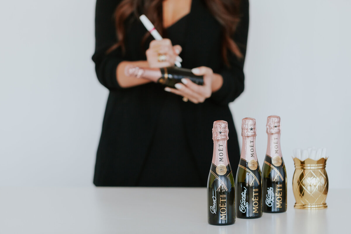 detail-photo-calligraphy-on-champagne-bottles-calligrapher-in-bakcground-for-brand-session-the-frame-charlotte