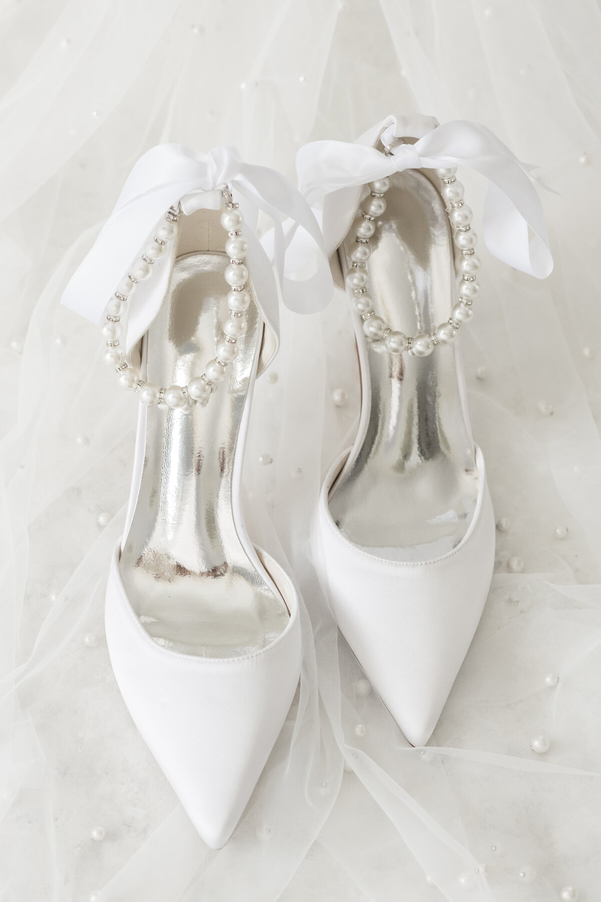 up close of bride's shoes with veil in the background