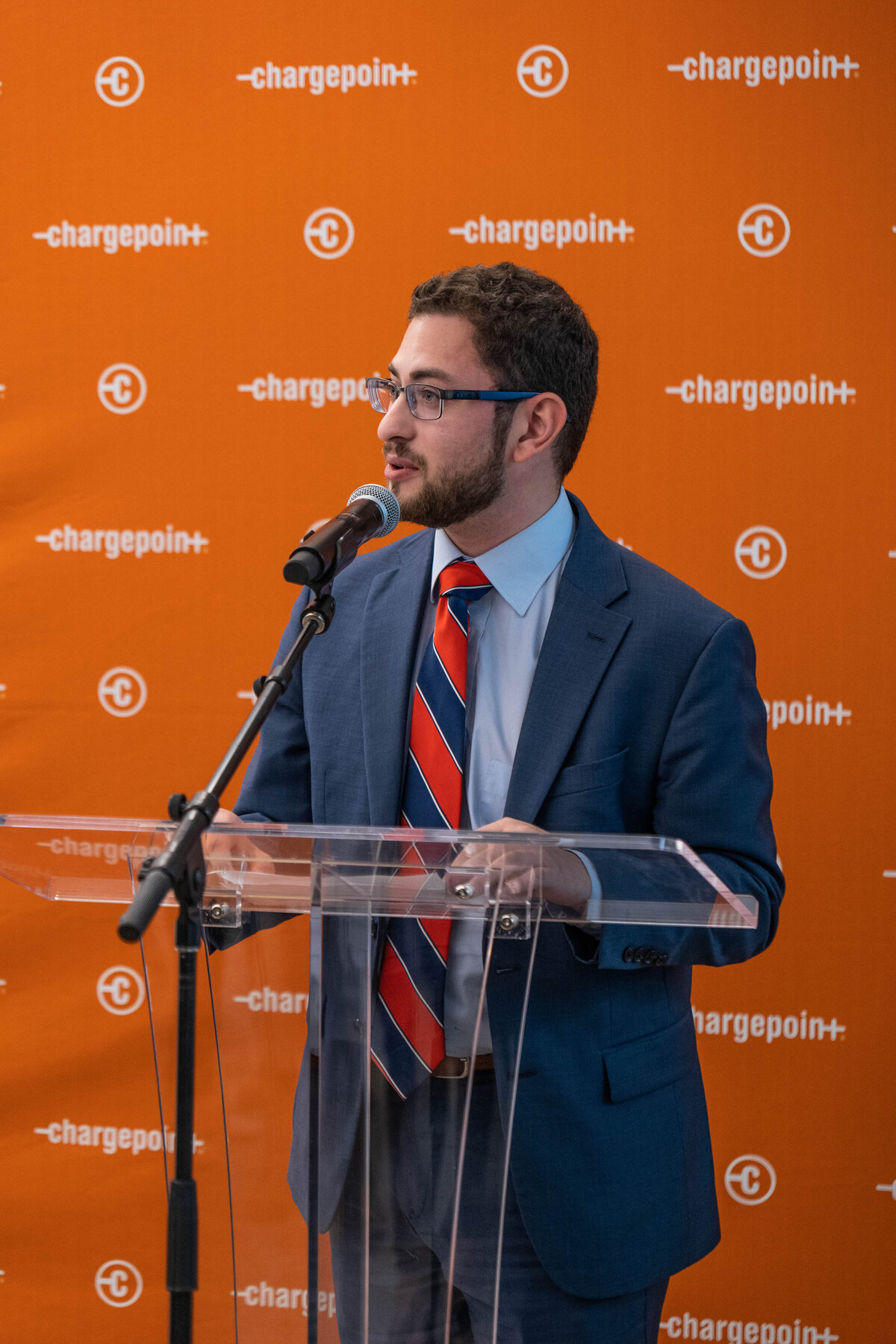 A person standing at a glass podium giving a speech 