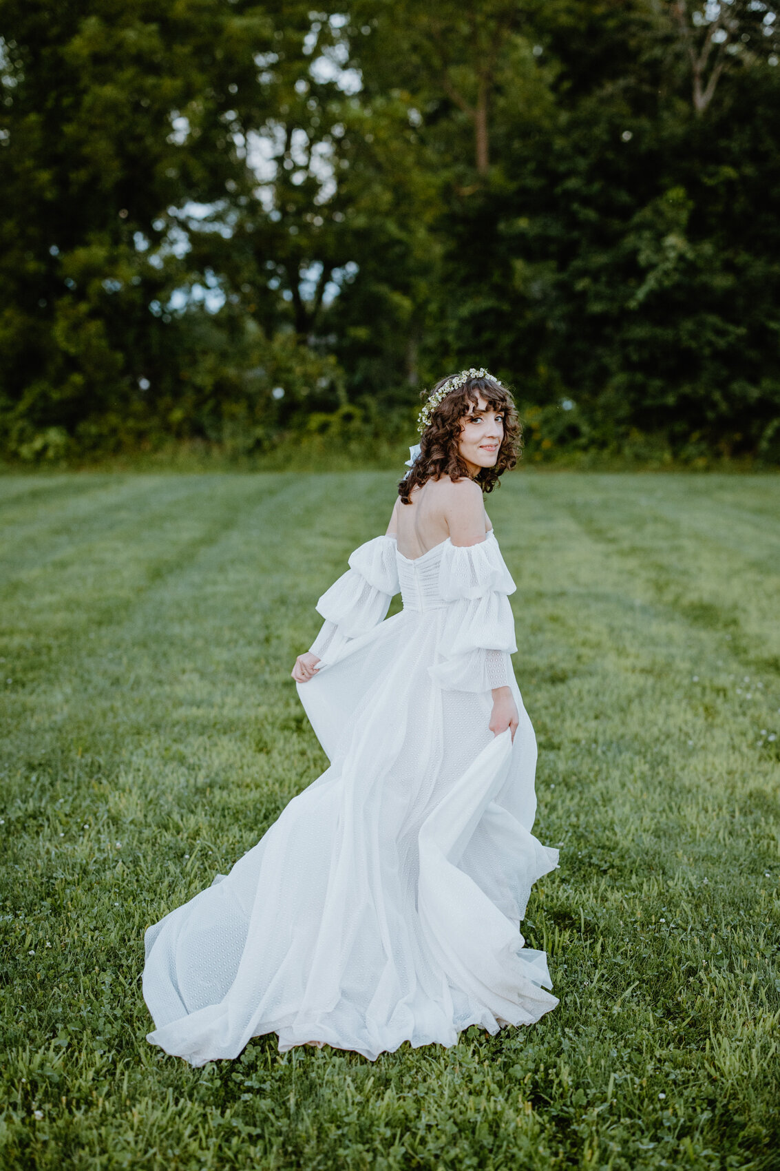 An editorial style bridal portrait. The wedding dress is big and flows beautifully in the wind.