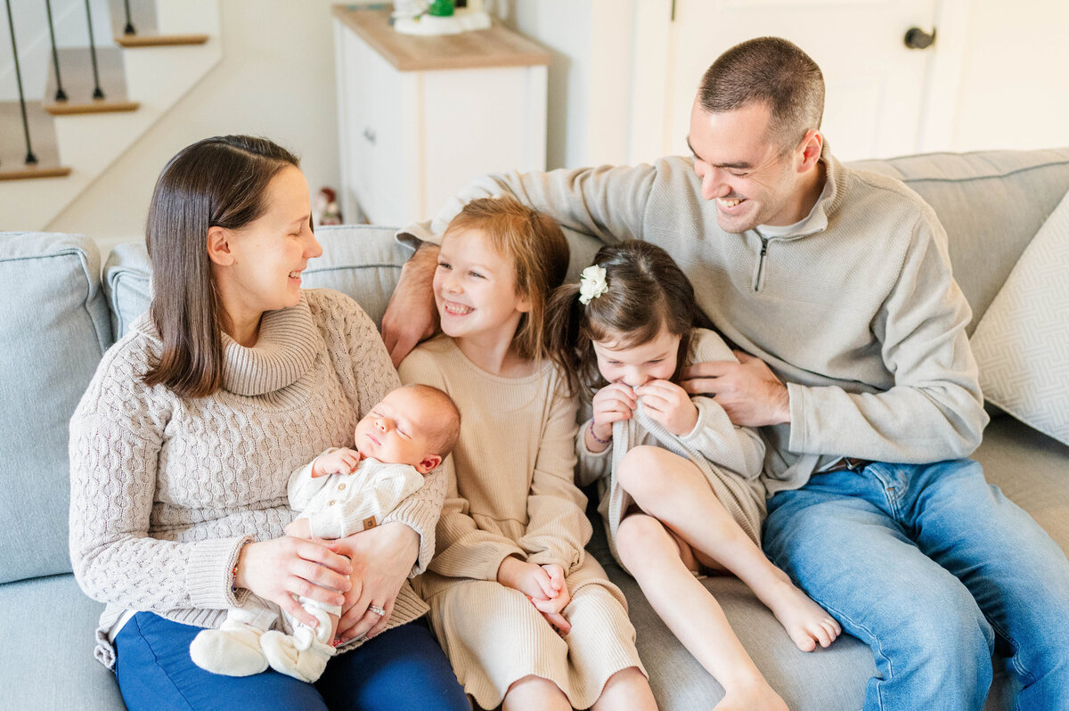 Family photo with mom, dad, big sisters, and newborn boy taken in Sutton, MA 