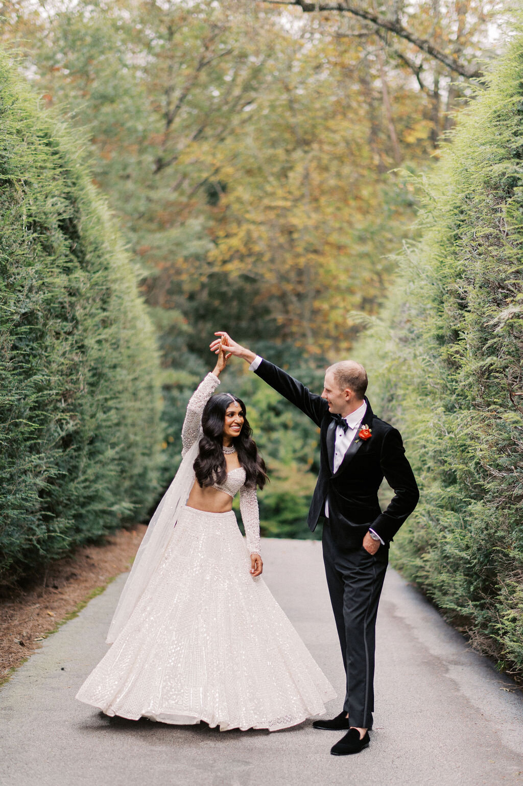 Groom twirls bride on a tree-lined garden path at Old Edwards Inn during their wedding in Highlands, NC.