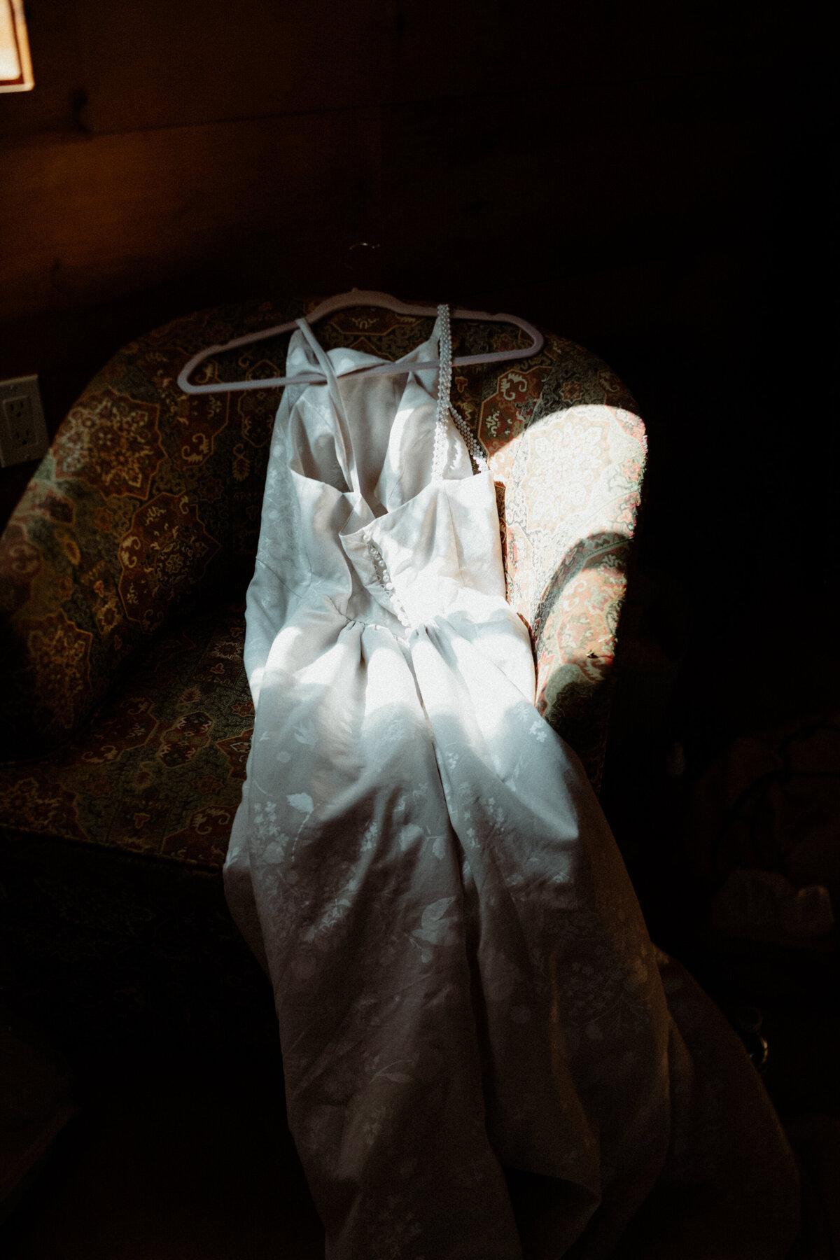 wedding dress on a chair with natural light falling on it