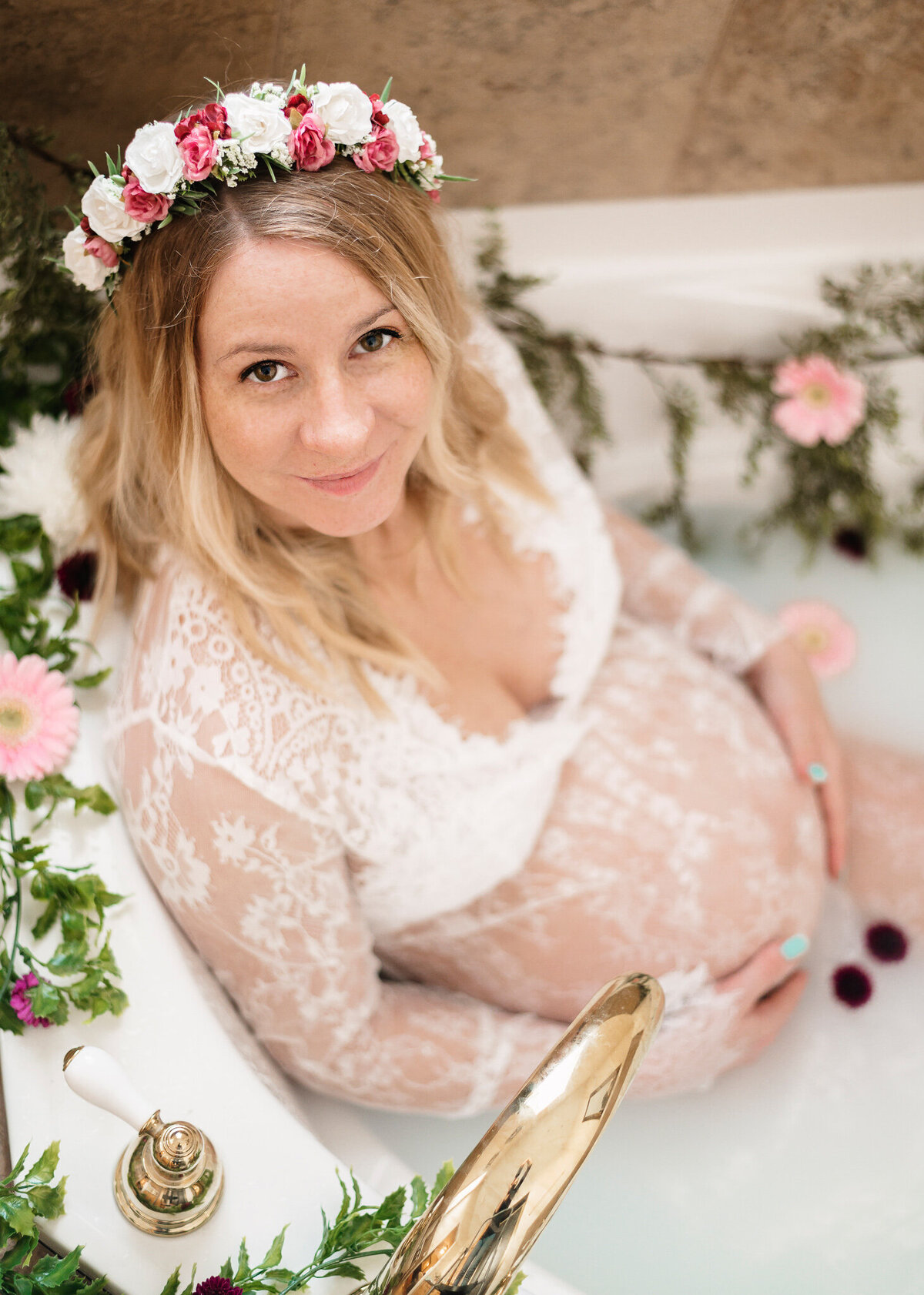 Maternity session of gorgeous mom wearing a lace robe in a floral covered white bathtub staring at the camera, by Greater Toronto Photographer, Tamara Danielle Photography