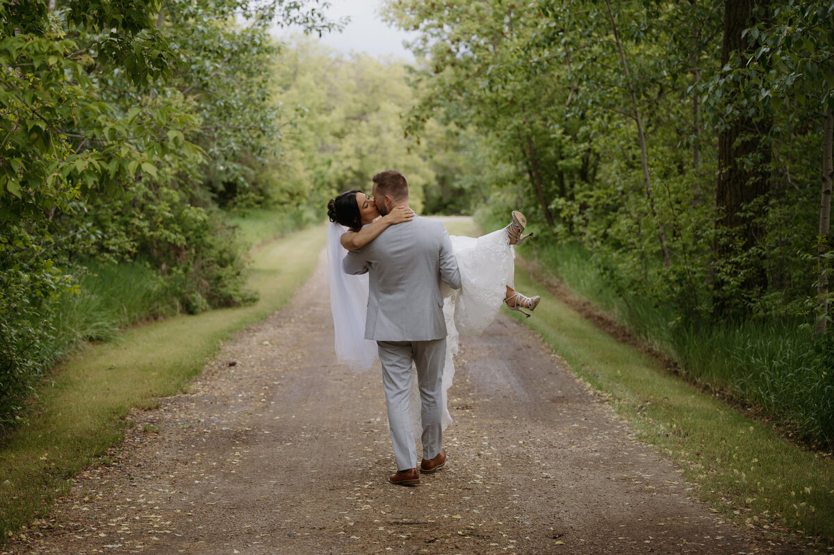 groom carrying bride during couples photos