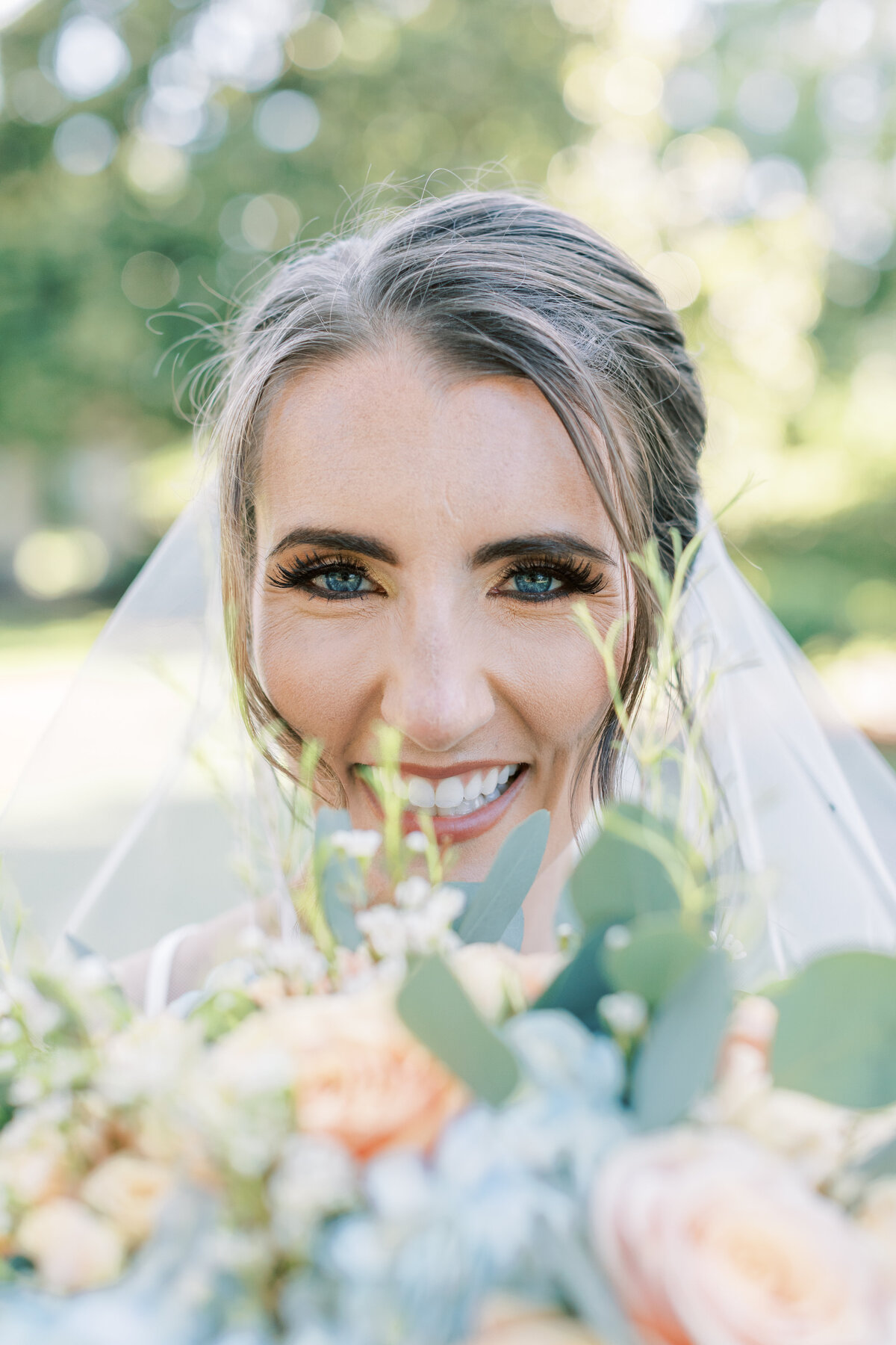 A bride smiles with her blue eyes.