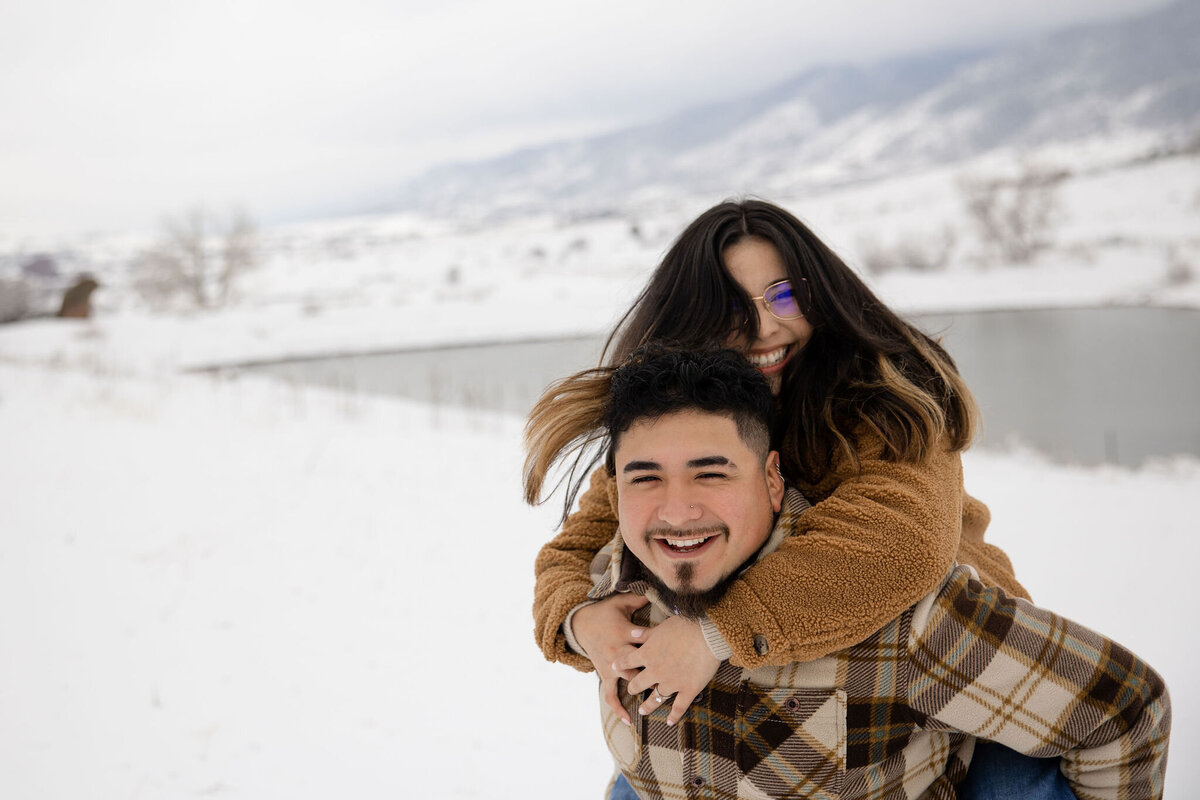Fun piggy back ride during photoshoot for couple on vacation in Denver