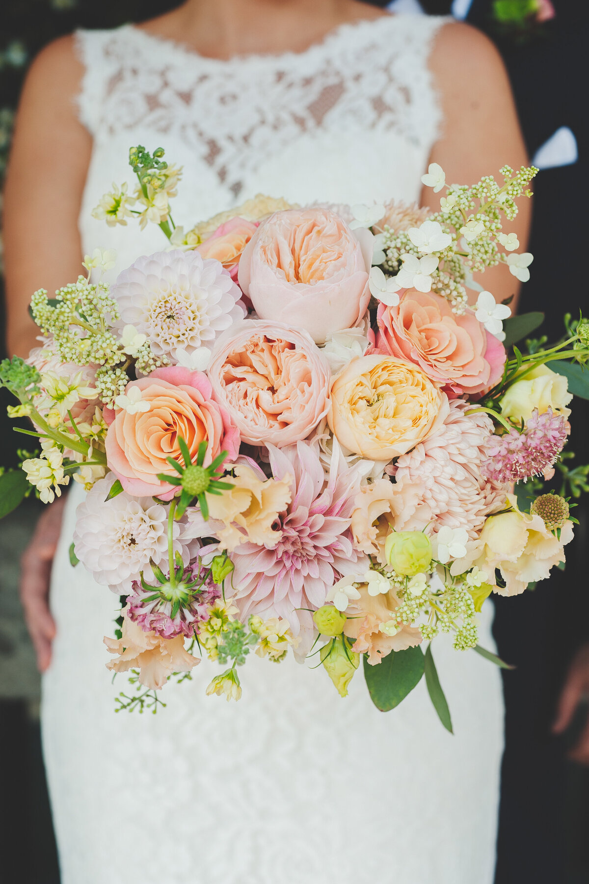 A bright bouquet of pink and orange roses and dahlias at a Montreal wedding. 