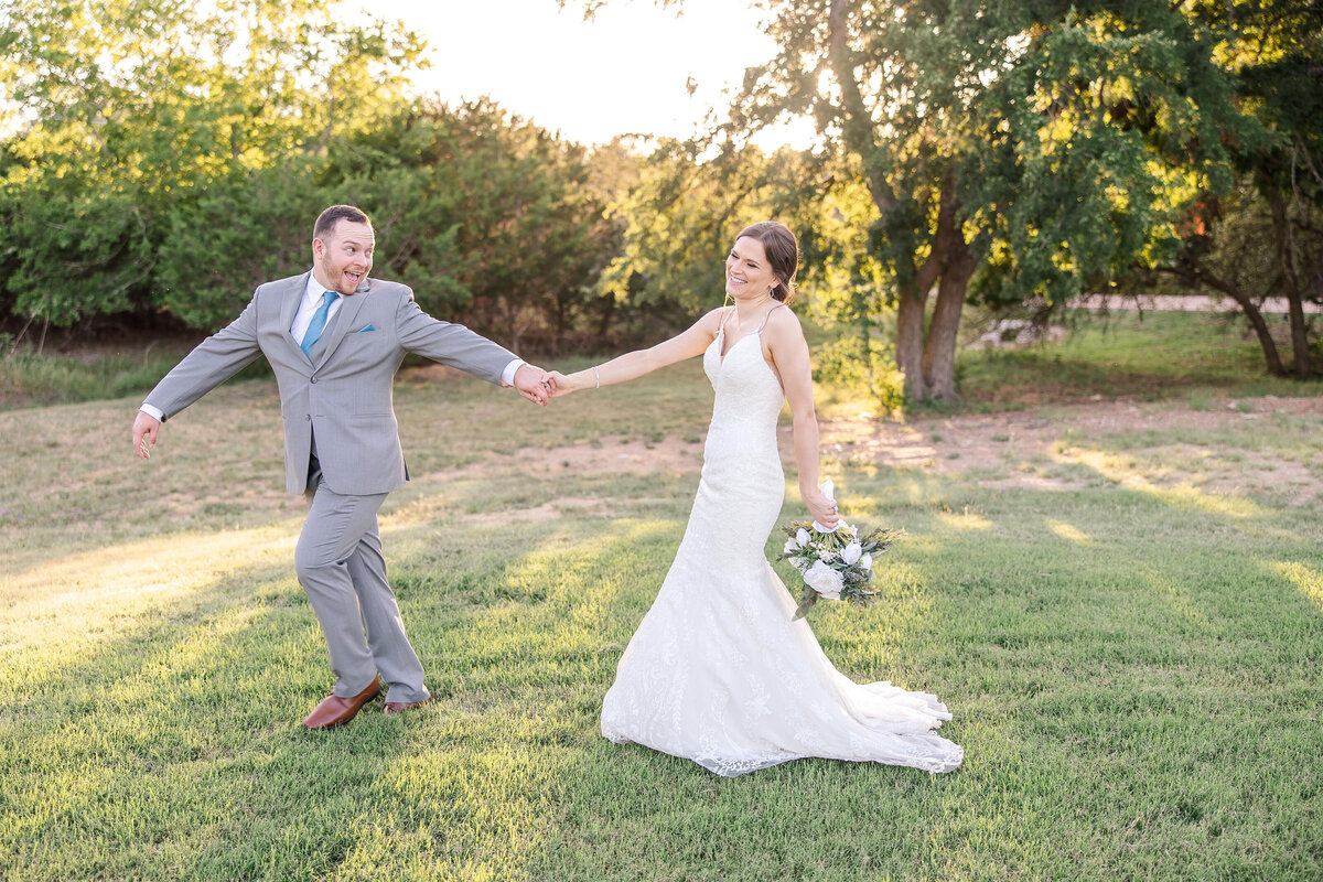 groom leads bride through sunset tree shadows at Austin area wedding