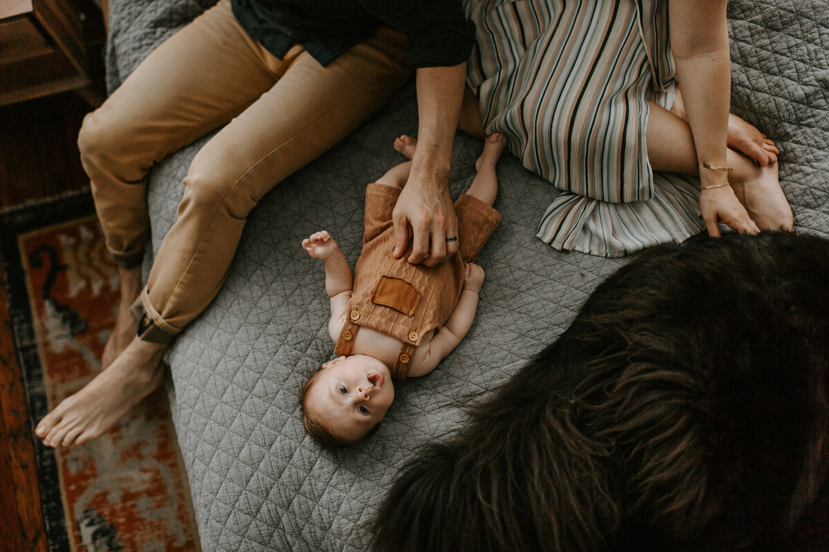 Newborn Photographer, little boy leaning on mother's lap